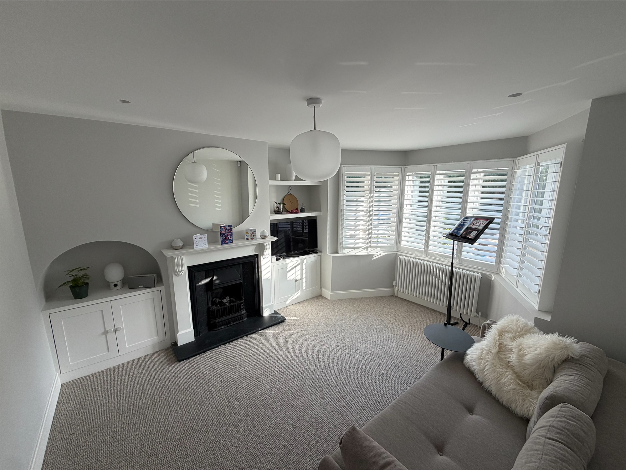 Living room with fireplace, alcove joinery and bay window shutters