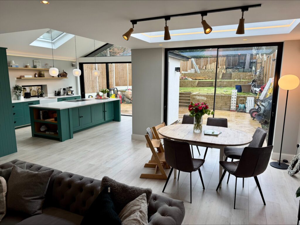 Open-plan dining area with track lighting and full-width glazing